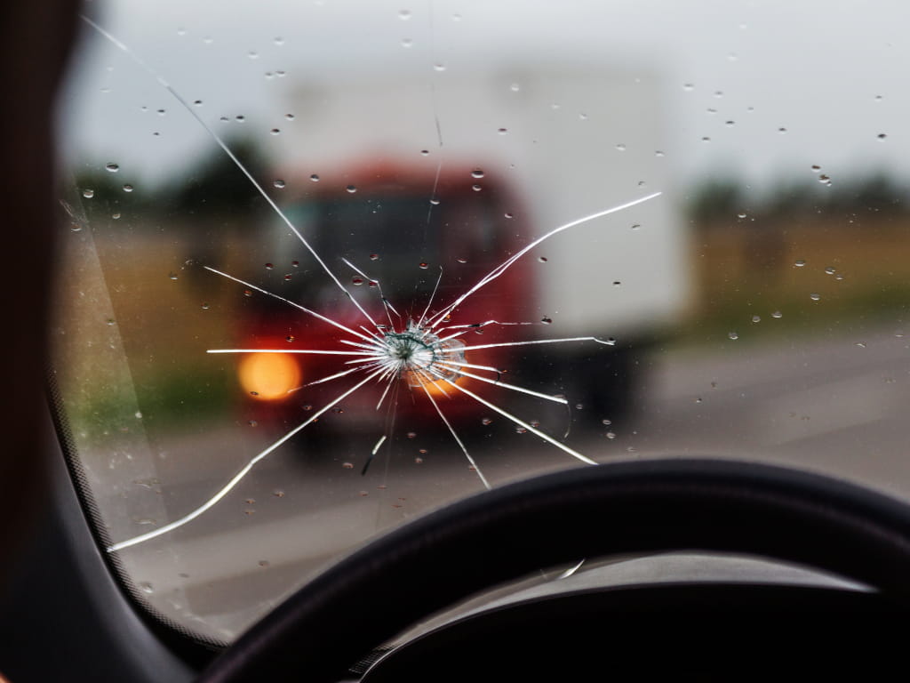Close-up of a rock chip crack on a vehicle windshield in Cranbrook, BC – eligible for ICBC repair coverage