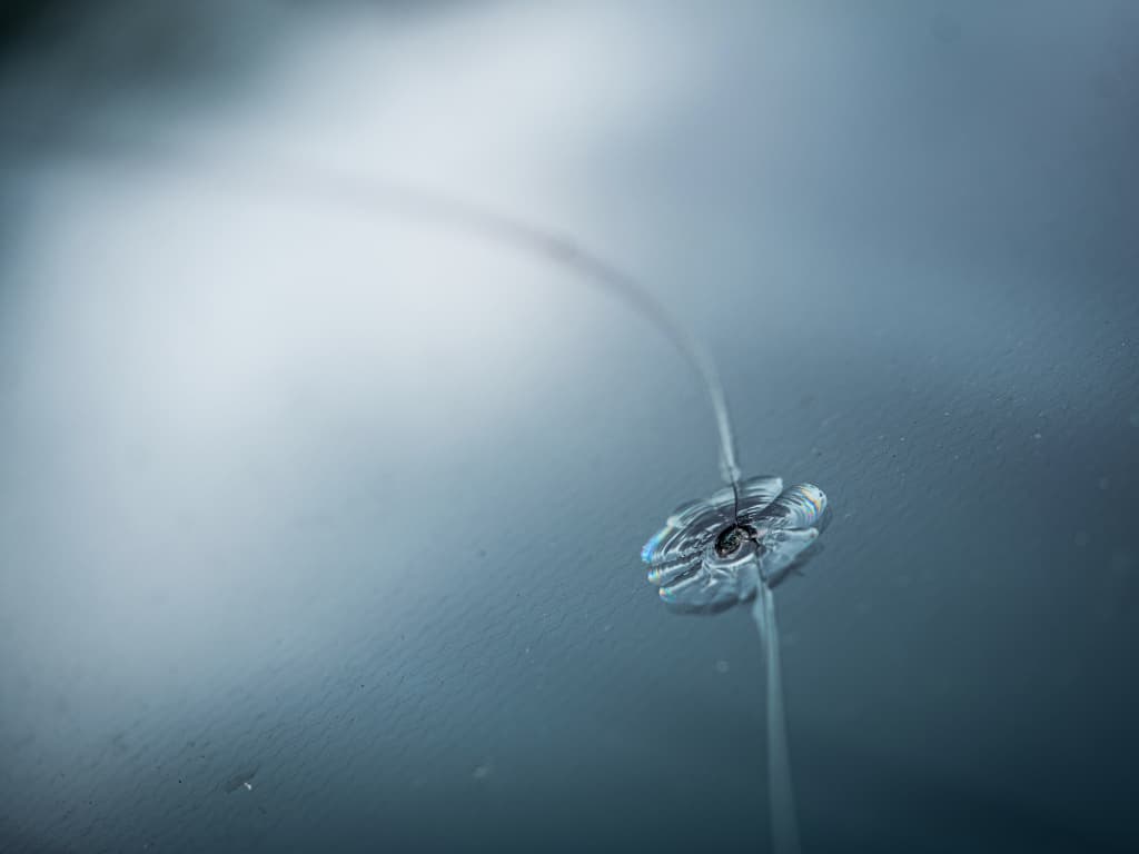 Close-up of a car windshield with a small rock chip crack