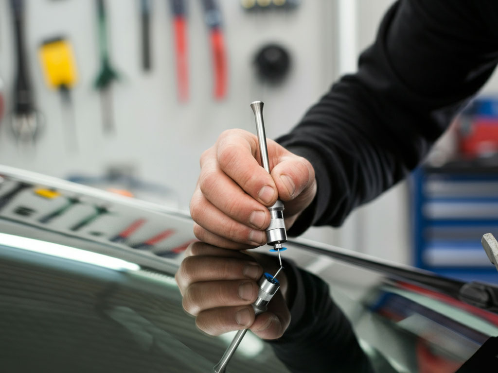 Rock chip repair technician working on a windshield