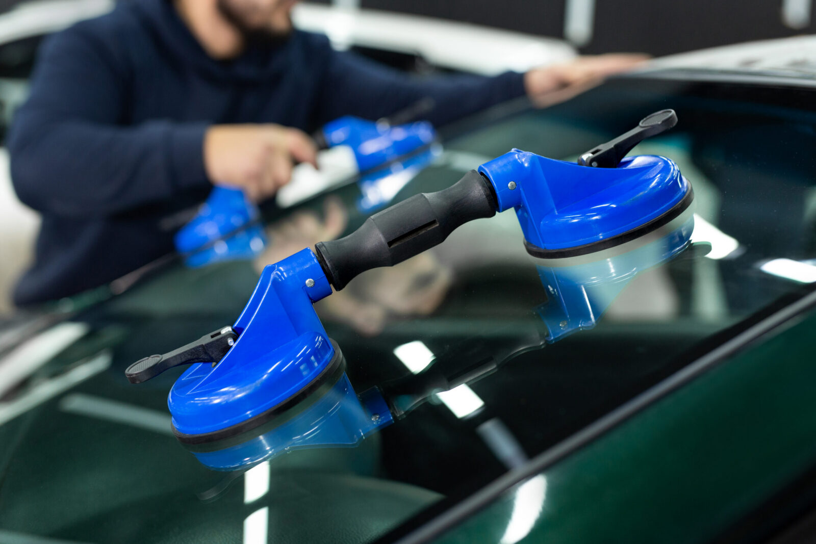 Auto glass technician preparing a vehicle for windshield service